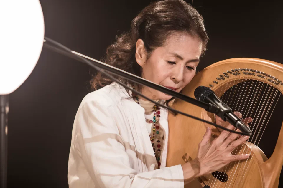ライアーを奏でながら歌う木村弓さん