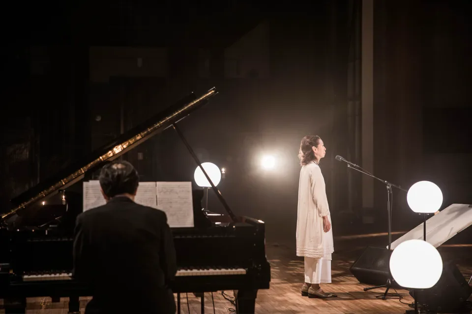 ピアノの伴奏に合わせて劇場で歌う木村弓さん